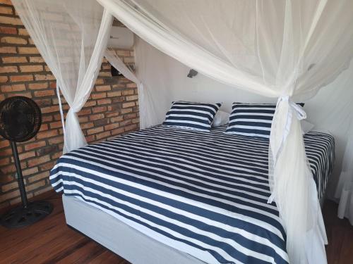 a bedroom with a bed with blue and white stripes at Bama Breeze Beach Villas in Miramar