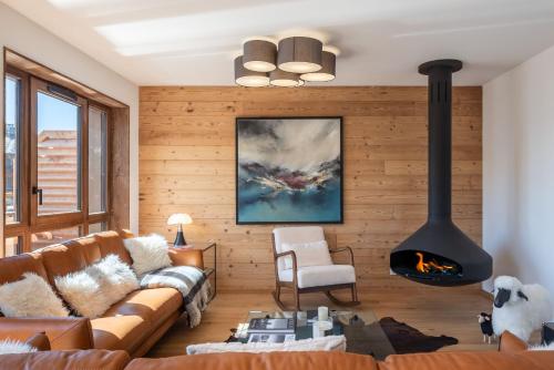 un salon avec un canapé et une cheminée dans l'établissement Apartment Ecrin Alpe d'Huez - BY EMERALD STAY, à Huez