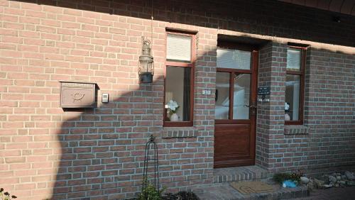a brick building with a door and a light on it at Ferienwohnung "Friesentied" 35229 in Hesel