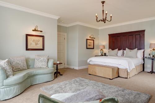 a bedroom with a large bed and a couch at Buccara Noetzie - Pezula Castle in Knysna