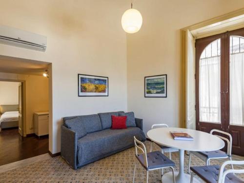 a living room with a couch and a table at Porticciolo sea view in Aci Castello