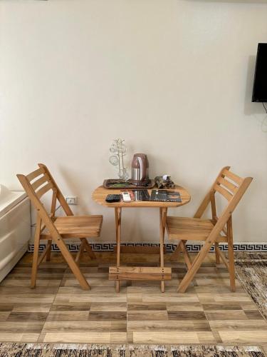 a table with two chairs and a tea kettle on it at Luxury Panorama pyramids & jacuzzi in Cairo
