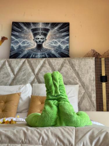 a green hand is on top of a bed at Luxury Panorama pyramids & jacuzzi in Cairo