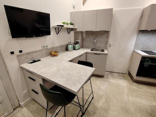 - une cuisine avec un comptoir, 2 chaises et un évier dans l'établissement Apartment Cosy in Montpellier, à Montpellier