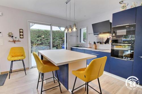 une cuisine avec des armoires bleues et des chaises jaunes dans l'établissement Kib arm, à Saint-Pierre-Quiberon