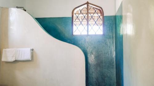 ワタムにあるKiboko Nyumbaの窓付きのバスルーム、洗面台、トイレが備わります。