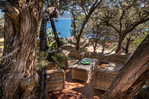 un groupe de chaises en osier et une table sur une terrasse dans l'établissement Charmant appartement vue mer, à La Celle-sous-Gouzon