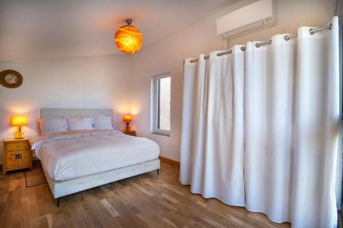 - une chambre avec un lit et un rideau blanc dans l'établissement Charmant appartement vue mer, à La Celle-sous-Gouzon