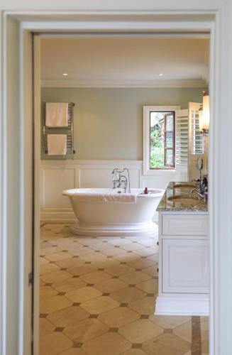 a large bathroom with a tub and two sinks at Buccara Noetzie - Pezula Castle in Knysna