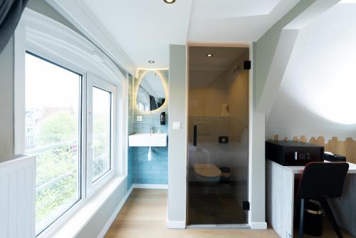 baño con ventana grande y aseo en The Crown Hotel, en Ámsterdam