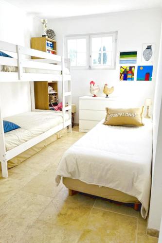 - une chambre avec 2 lits superposés et des murs blancs dans l'établissement Nice Holiday home Grimaud, à Grimaud