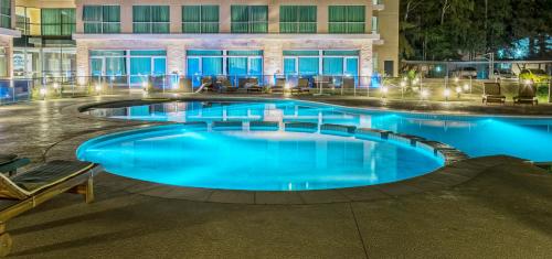 a large swimming pool in a hotel at night at Howard Johnson Neuquen in Neuquén