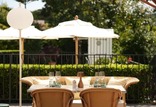 a table with chairs and umbrellas on a patio at Villa Miraé by Inwood Hotels - Cap d'Antibes in Antibes