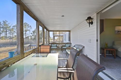a screened in porch with a table and chairs at Island Retreat in Birch Town