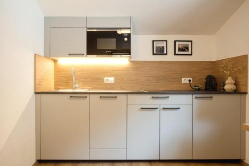a kitchen with white cabinets and a sink at Apartment MarLen in Eben am Achensee