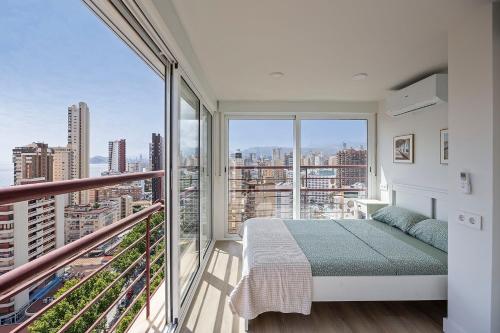 een slaapkamer met een bed en een groot raam bij Mucho Gusto Coblanca 3 in Benidorm
