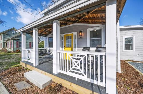a front porch of a house with a yellow door at Hudson House in Chincoteague