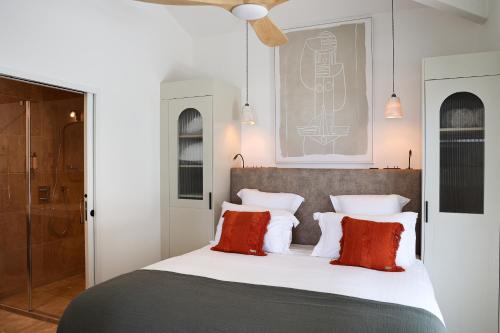 une chambre avec un lit avec des oreillers rouges et blancs dans l'établissement Residence Les Suites Pereire, à Arcachon