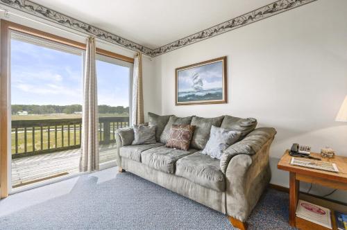 a living room with a couch and a large window at Assateague Inn 202-S in Deep Hole