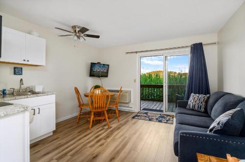 eine Küche und ein Wohnzimmer mit Sofa und Tisch in der Unterkunft Assateague Inn 106-S in Deep Hole