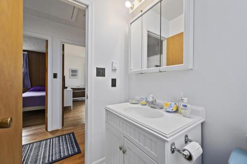 a white bathroom with a sink and a mirror at Lily Pad in Chincoteague