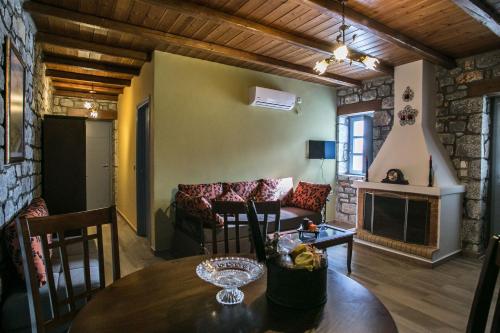 a living room with a table and a couch at Εn Plo Luxury Suites in Karavostasion