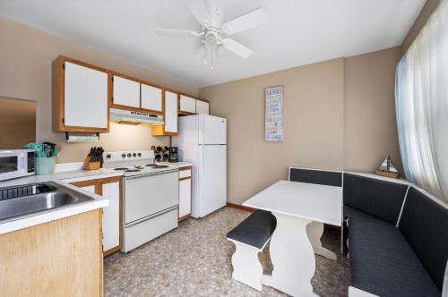 a kitchen with a table and a white refrigerator at Fishhook Hideaway in Chincoteague