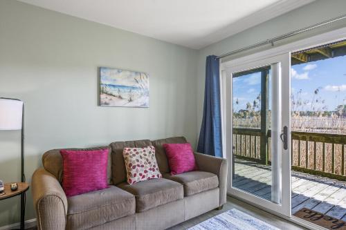 Una sala de estar con un sofá y un balcón. en Assateague Inn 105-S, en Deep Hole