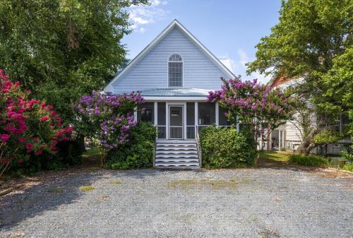 una chiesa con fiori viola davanti a un vialetto di Sea Glass a Chincoteague
