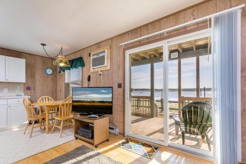 a living room with a television and a table with chairs at Sunrise Sonata in Birch Town