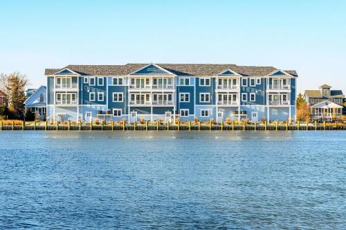 a large blue and white building next to the water at At The Waters Edge in Chincoteague