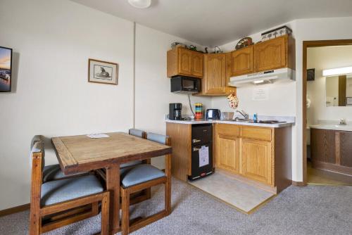 a small kitchen with a wooden table and a small table at Assateague Inn 205-S in Deep Hole