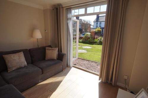 a living room with a couch and a sliding glass door at Stockmans Stay, Belfast in Belfast