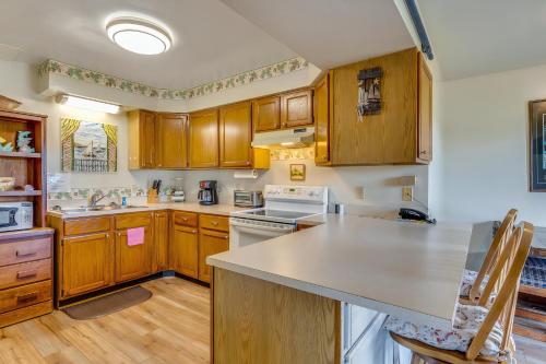 a kitchen with wooden cabinets and a white stove top oven at Assateague Inn 107-A in Deep Hole