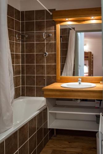 une salle de bain avec un lavabo, une baignoire et un miroir dans l'établissement Apartment for 4 to 6 people in Albiez-Montrond, à Albiez-Montrond