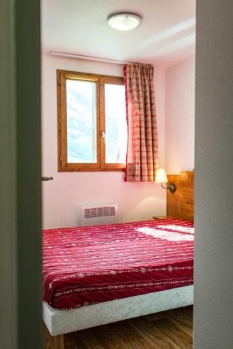 - une chambre avec un lit rouge et une fenêtre dans l'établissement Apartment for 4 to 6 people in Albiez-Montrond, à Albiez-Montrond