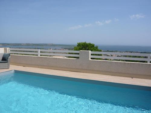 - une piscine en face d'une clôture et de l'océan dans l'établissement Vue panoramique imprenable sur la Méditerranée, à Fitou