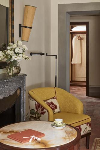 a living room with a yellow chair and a table at Villa San Michele, A Belmond Hotel, Florence in Fiesole