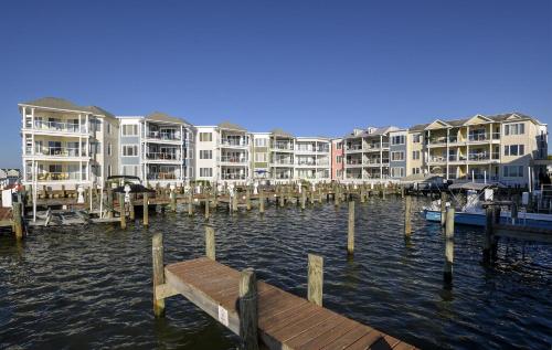 Un muelle en el agua frente a unos edificios de apartamentos. en Sunset Bay Villa 309 - Changes In Latitude, en Chincoteague