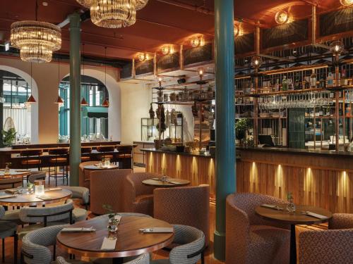 a restaurant with tables and chairs and a bar at Vana Spa Snäckviken by Elite - A proud member of The Leading Spa Hotels of Sweden in Södertälje