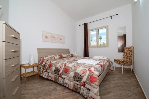 a bedroom with a bed and a dresser and a chair at Villa Marika in Fontane Bianche