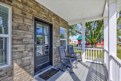 a stone house with two chairs on a porch at Saltwater Pony in Black Point Landing