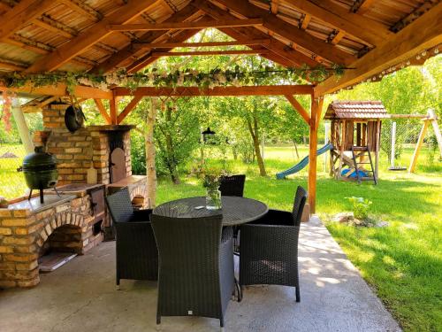 a patio with a table and chairs under a pavilion at Gárdonyi Ház in Sály