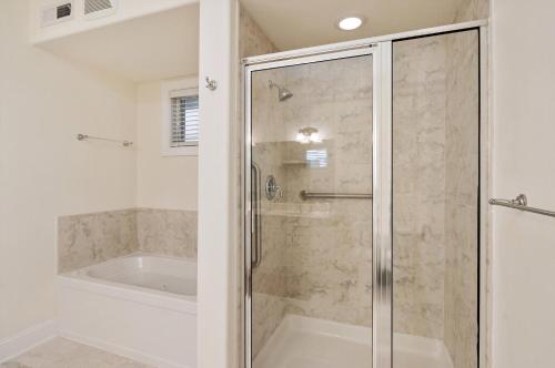 a bathroom with a shower and a tub and a shower stall at Sunset Bay Villa 220 - Vista Costiera in Chincoteague