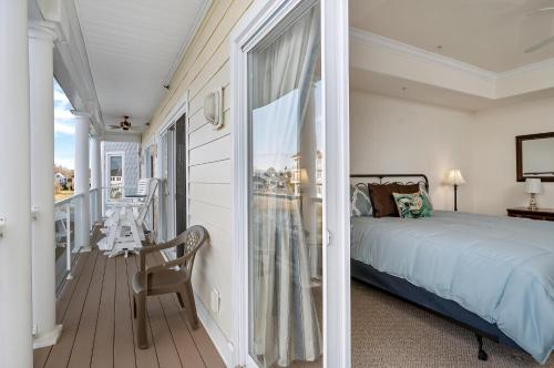 a bedroom with a bed and a balcony at Sunset Bay Villa 220 - Vista Costiera in Chincoteague