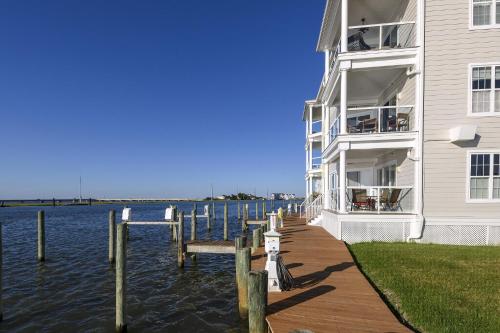a building with a dock next to a body of water at Sunset Bay Villa 220 - Vista Costiera in Chincoteague