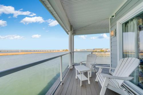 two chairs and a table on a balcony with a view of the water at Sunset Bay Villa 319 - Bella Vista in Chincoteague