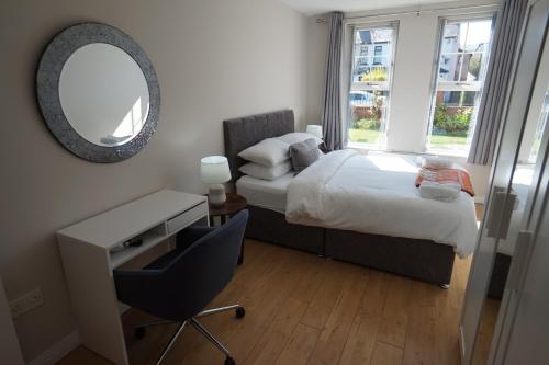 a bedroom with a bed and a desk and a mirror at Stockmans Stay, Belfast in Belfast