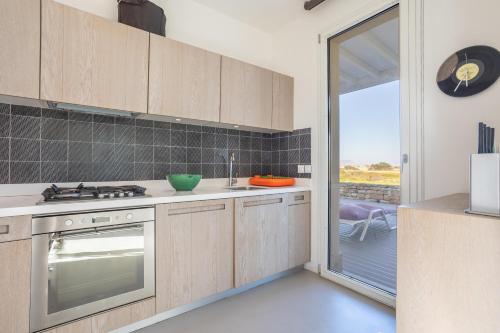 a kitchen with a stove top oven next to a window at Villa Partenope in Favignana