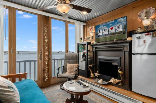 a living room with a fireplace and a view of the water at Waterfront Sunsets in Chincoteague